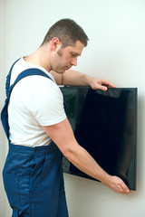 Man mounting TV on the wall.