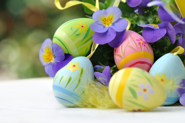 œufs de Pâques parmi fleurs et plume 