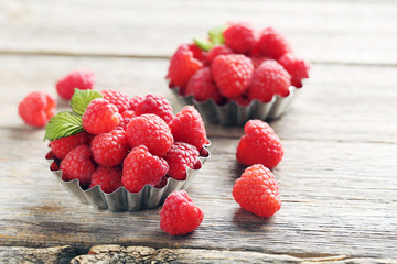 Red raspberries in bowl on a grey wooden table