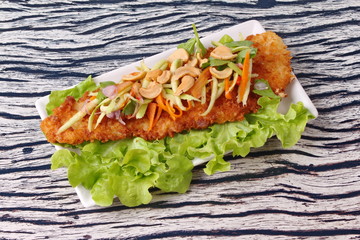 Spicy deep-fried Dolly's fish salad with roll green mango.