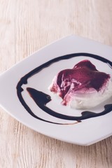 Vintage creamy dessert with berry sauce and chocolate topping