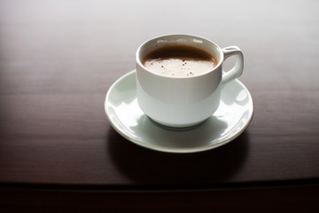 Cup of coffee on a wooden table.