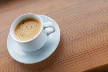 Cup of coffee on a wooden table.