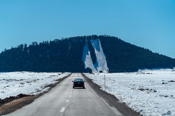 view of the road with snow and mountain background in winter season 
