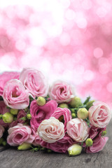 Beautiful bouquet of pink roses on wooden with pink blur bokeh b