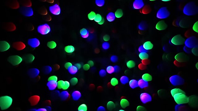 Abstract holiday background with fairy tale fast blinking lights. Christmas and new year twinkling decoration. Celebration spirit in flashing colorful specks on dark night backdrop in fancy HD clip.