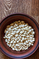 Peeled peanuts in an earthenware dish on a wooden table