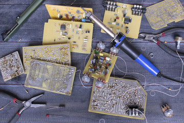 Soldering tools,  a soldering iron and micro circuits on the wooden background.