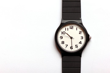 Classic uni-sexual black and white wrist watch on the white background, close up.