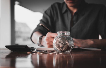 Close up of people hand work calculator and money,coins in finan