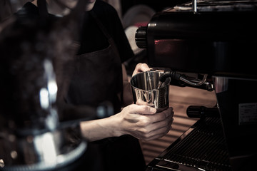 Barista Steams milk for a coffe in cafe with vintage concept