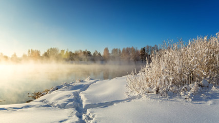 весенний пейзаж на берегу озера с туманом и деревьями в инее, Россия, Урал