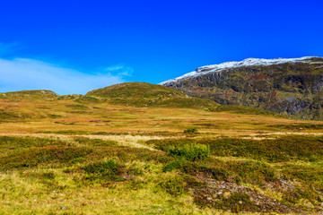 Fototapeta na wymiar Great landscape with fall colors and new snow on the mountain tops, in western Norway
