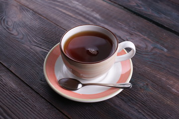 cup of black tea on a wooden table