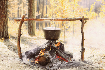 The fire near the camp. Cooking food on a fire. Journey into the wild concept.