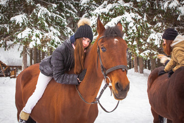 Young girl and horse in a winter forest