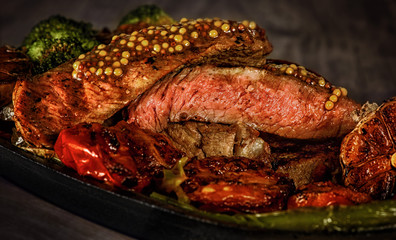 beef steak with blood, red pepper, broccoli, garlic, grilled served on a skillet