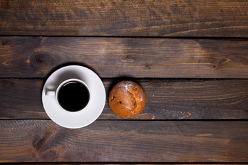 White coffee mug and cake on a wooden background