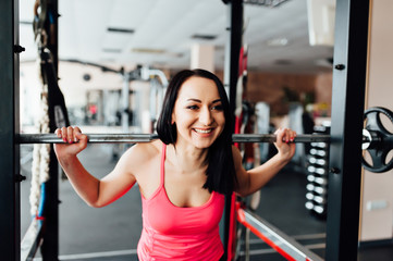 Fototapeta na wymiar Beautiful fitness woman lifting barbell.