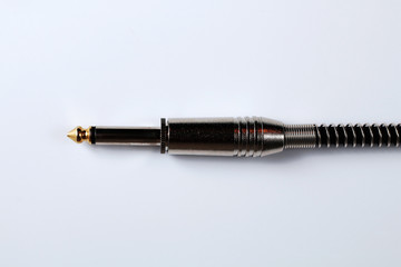 Cable jack for electric guitar on a white background