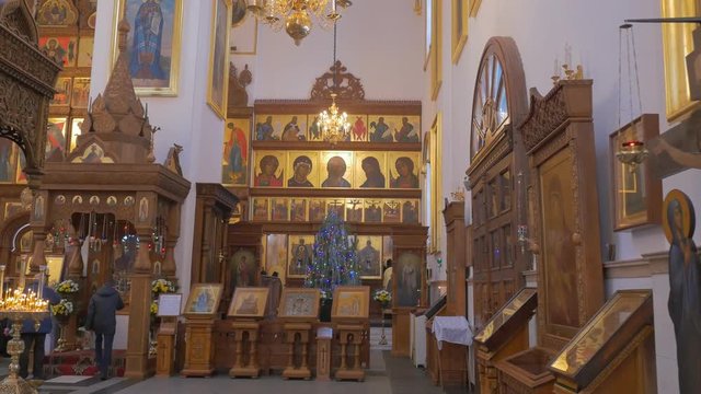 an Impressive Iconostasis and Golden Looking Icons Inside of an Old Orthodox Cathedral With Several Praying People in it