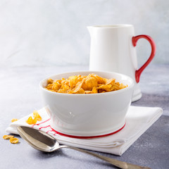 Corn flakes with milk on light gray background. Copy space. Healthy breakfast concept.