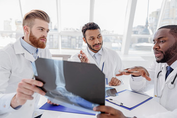 Fototapeta premium Poważni lekarze pierwszego kontaktu omawiają obraz rentgenowski