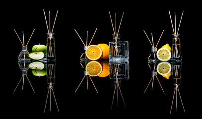 Air fresheners in a glass jars with sticks and lemon, green apple and orange with reflection isolated on a black background. Big large size. 
