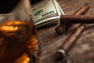 Smoking cigarette, glass with brandy and money