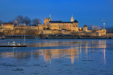 Evening view of the Akershus Fortress in Oslo, Norway. View from the Aker Brygge Marina across the Pipervika bay of Oslofjord.