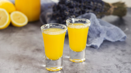 Yellow fresh shot cocktail or lemonade with lemon