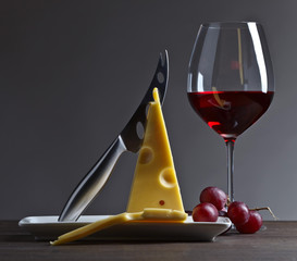 Cheese and red wine on a old wooden table