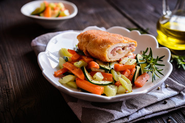 Chicken breasts chops stuffed with English bacon and Edam cheese, served, with steamed vegetable