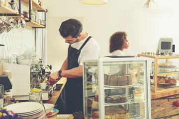 Barista preparing delicious coffee in cafeteria