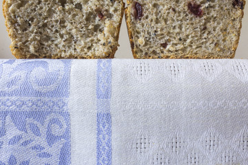 Two piece of homemade bread with cranberries . The Polish kitchen. Brown bread made from rye on a light background.