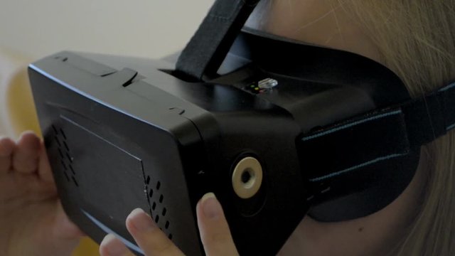 closeup of Teenager girl going up and down with her head in vertual glasses