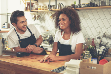 Outgoing baristas speaking during their work in sunny cafe