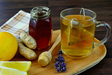 Cup of ginger tea with lemon and honey on wooden background. Natural fresh healthy drink. Spicy flu...