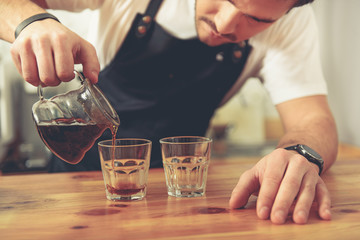 Serene barista filling cups from teapot