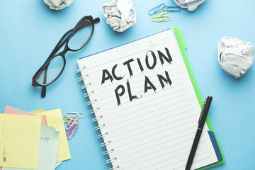 action plan text on notebook with stationary