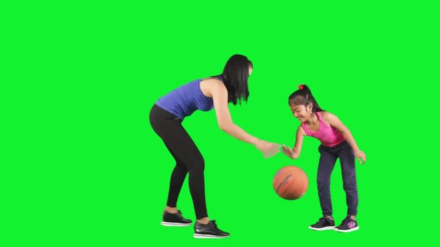 Child and mother playing basketball