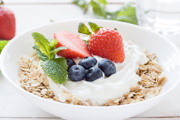 Morning healthy breakfast with muesli and berries on the white background. 