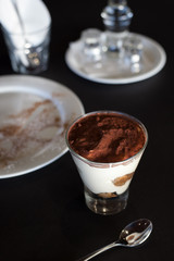 Tiramisu dessert in glass with table decoration dark food photography