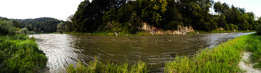 Panorama of muddy river Poprad and surrounding forest