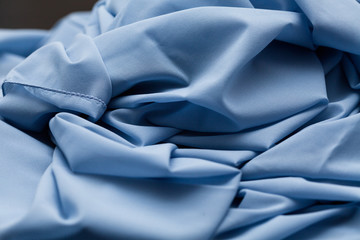 Blue light cloth, fabric, textile with a lot of folds, plaits , creases