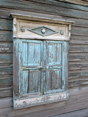 The window closed with wooden shutters in the old wooden house in the historic center of Barnaul, Altai region, Russia 