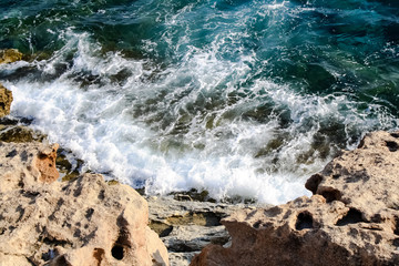 Seawater waves hit the rocks and forms a foam. Cyprus
