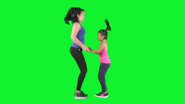 Girl and mother jumping in studio
