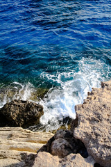 Seawater waves hit the rocks and forms a foam. Cyprus