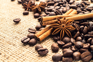 Coffee beans with cinnamon and anise on the sackcloth